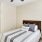 a bed in a room with carpet and yellow walls