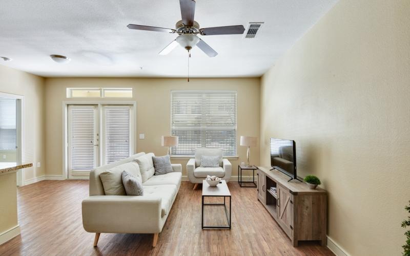 a living room with a white couch and a white ceiling fan