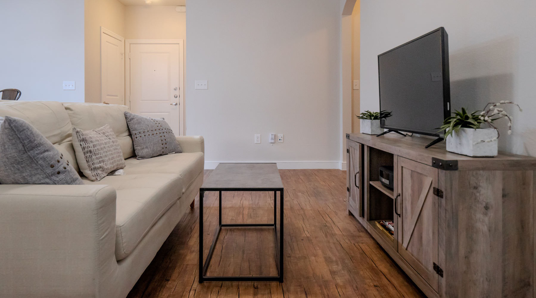 Wide open living areas flooded with natural light a living room with a white couch and a television